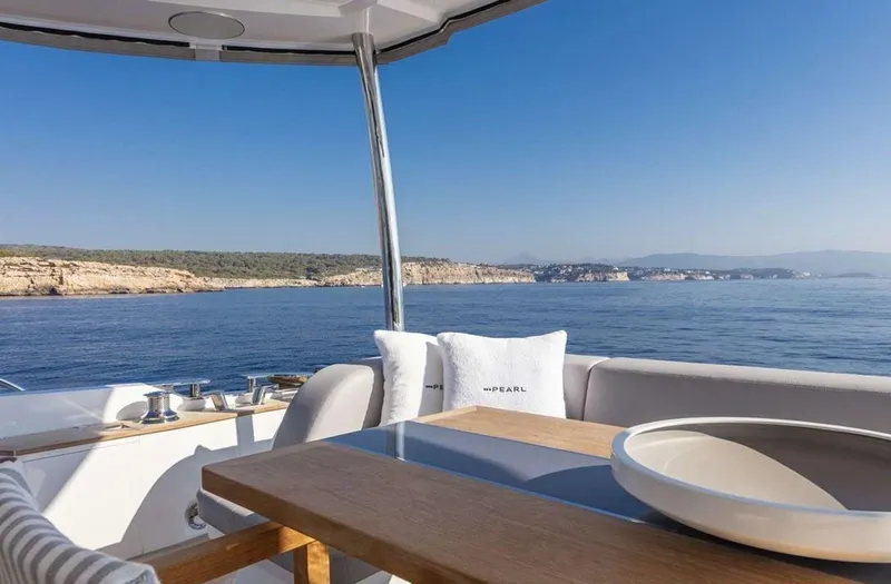  Yacht Photos Pics Luxurious Pearl 80 yacht deck with ocean view, featuring elegant seating and table, 2020 model.
