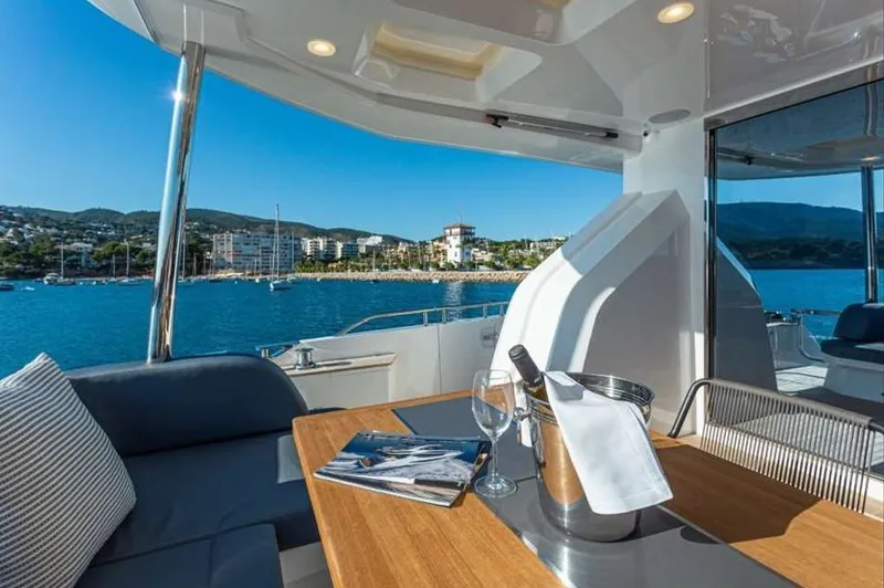  Yacht Photos Pics Luxurious Pearl 80 yacht interior with ocean view, featuring a table set with wine and glasses.