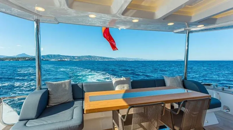  Yacht Photos Pics Luxurious Pearl 80 yacht deck with seating, table, and ocean view, 2020 model.