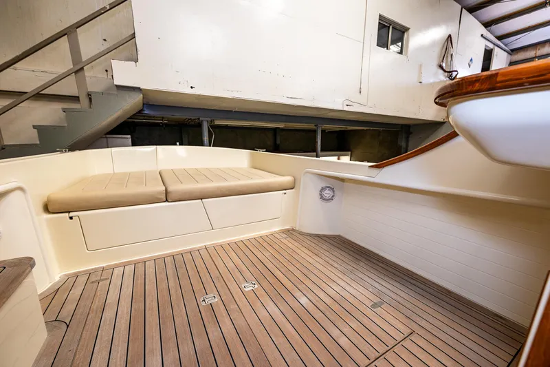 Rough Rider Yacht Photos Pics 2006 Palm Beach Motor Yachts Avalon 32 interior with wooden deck and cushioned seating.