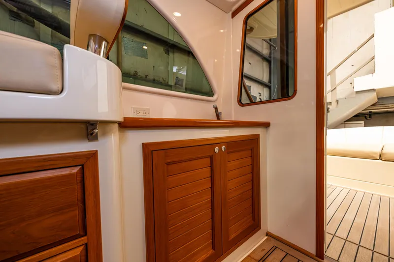 Rough Rider Yacht Photos Pics Interior of 2006 Palm Beach Motor Yachts Avalon 32, featuring elegant wood cabinetry and seating.