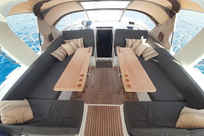  Yacht Photos Pics Luxurious Jeanneau Yachts 64 cockpit with cushioned seating and wooden tables, 2015 model.