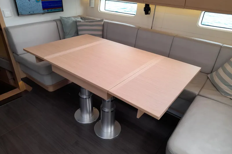  Yacht Photos Pics Luxurious interior of 2015 Jeanneau Yachts 64 with elegant dining table and seating.