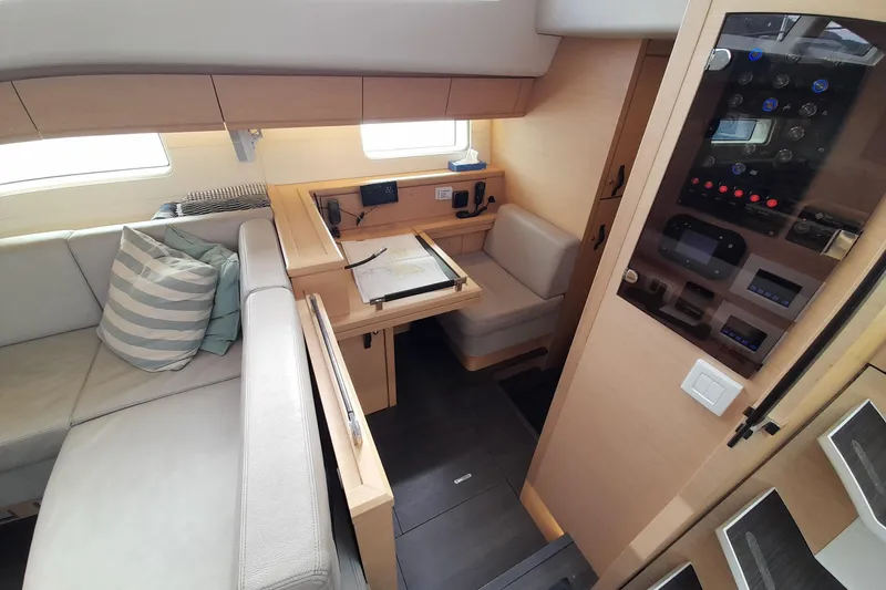 Yacht Photos Pics Interior of 2015 Jeanneau Yachts 64, featuring a cozy seating area and navigation station.