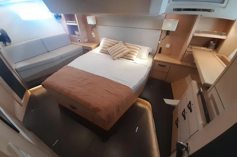  Yacht Photos Pics Luxurious cabin interior of 2015 Jeanneau Yachts 64 with cozy bed and modern furnishings.