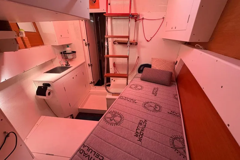  Yacht Photos Pics Cozy interior of 2015 Jeanneau Yachts 64 with bed, sink, and ladder.