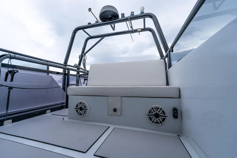  Yacht Photos Pics 2023 Vandal 46 Explorer boat interior with seating and speakers, under a cloudy sky.