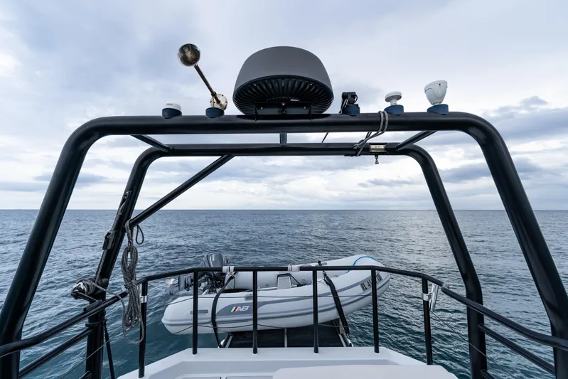  Yacht Photos Pics 2023 Vandal 46 Explorer yacht with dinghy on open sea, under cloudy sky.