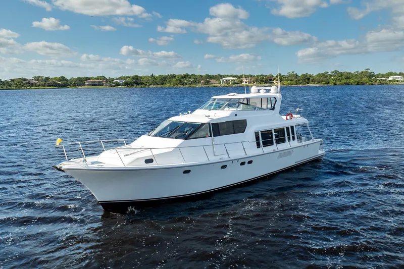Last Call Yacht Photos Pics 2009 Pacific Mariner 65 Motoryacht cruising on a sunny day, surrounded by blue water.