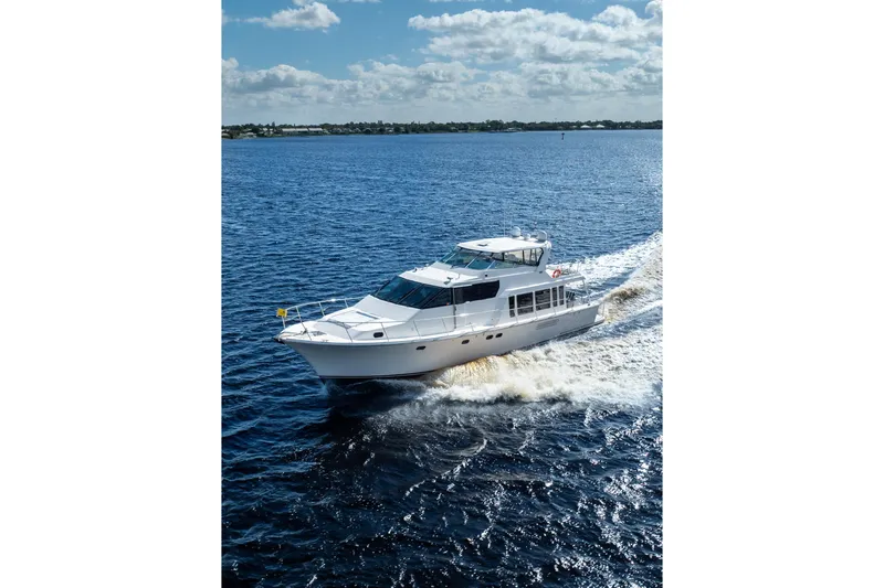Last Call Yacht Photos Pics 2009 Pacific Mariner 65 Motoryacht cruising on open water under a partly cloudy sky.