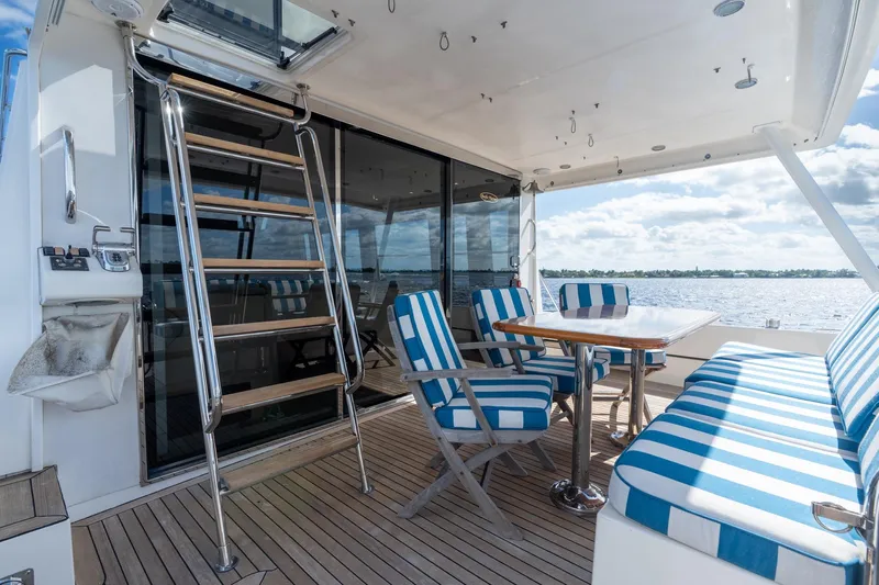 Last Call Yacht Photos Pics 2009 Pacific Mariner 65 Motoryacht deck with striped seating and ocean view.