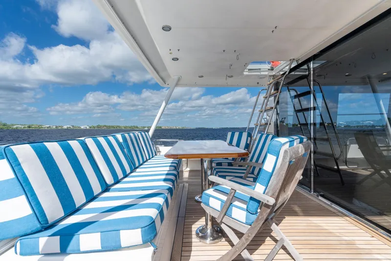 Last Call Yacht Photos Pics Luxurious 2009 Pacific Mariner 65 Motoryacht deck with striped seating and ocean view.