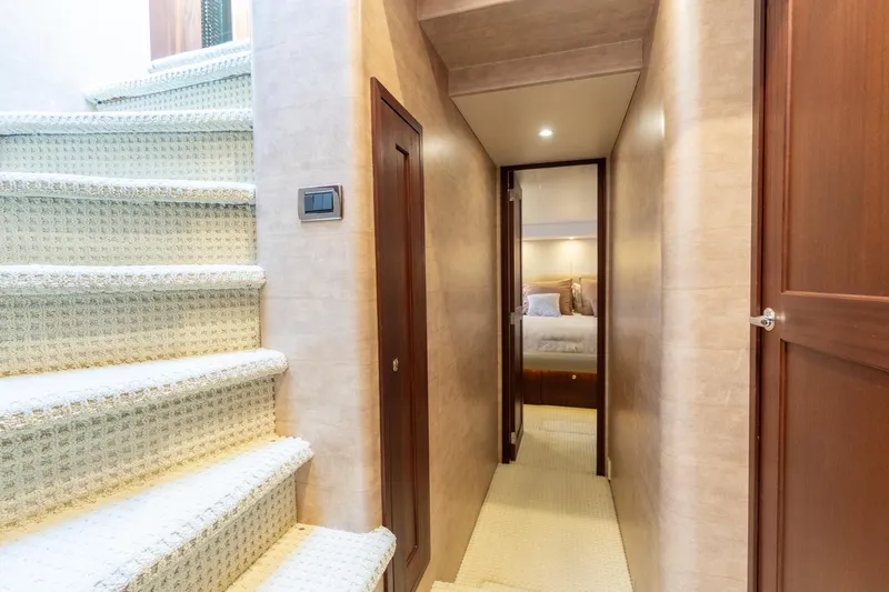 Last Call Yacht Photos Pics Interior hallway of 2009 Pacific Mariner 65 Motoryacht with carpeted stairs and cozy bedroom.