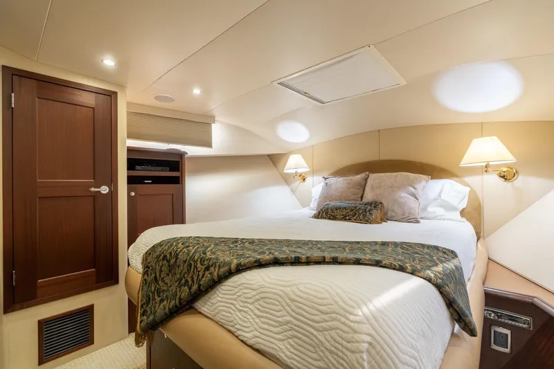 Last Call Yacht Photos Pics Luxurious bedroom interior of 2009 Pacific Mariner 65 Motoryacht with elegant bedding and warm lighting.