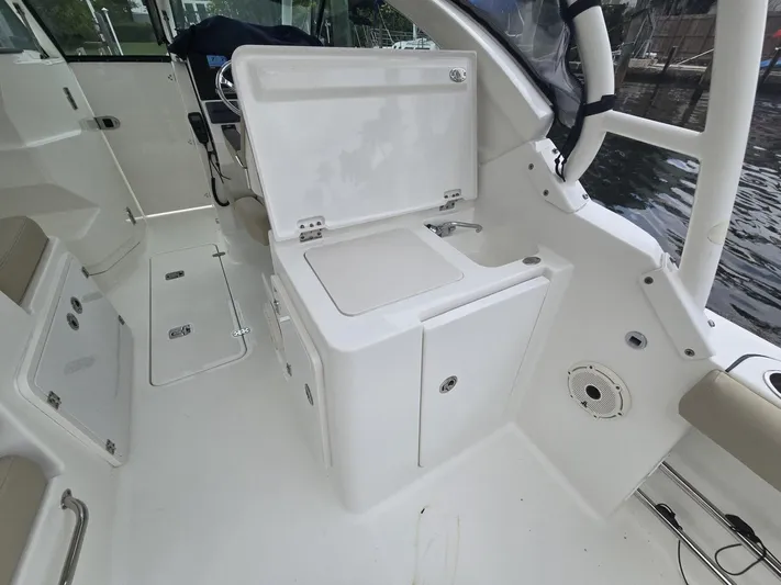  Yacht Photos Pics 2020 Pursuit 266 boat interior with open storage compartment and seating area.