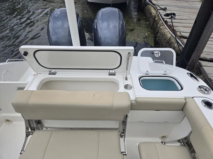  Yacht Photos Pics 2020 Pursuit 266 boat with open storage compartments and dual engines at dock.