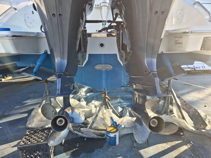  Yacht Photos Pics 2020 Pursuit 266 boat with dual outboard motors and propellers, docked for maintenance.