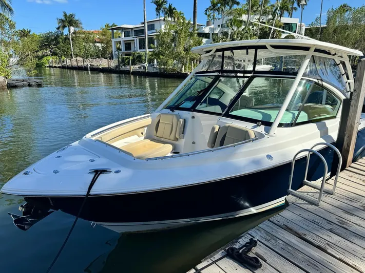  Yacht Photos Pics 2020 Pursuit 266 boat docked by a scenic waterfront.