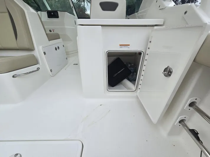  Yacht Photos Pics Open storage compartment on 2020 Pursuit 266 boat interior, featuring white seating and sleek design.