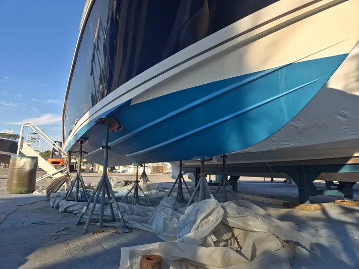  Yacht Photos Pics 2020 Pursuit 266 boat on stands, undergoing maintenance with blue hull visible.