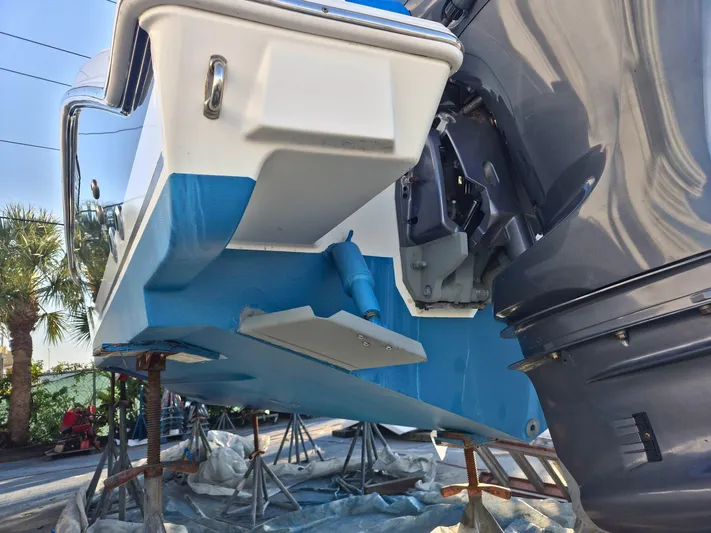  Yacht Photos Pics 2020 Pursuit 266 boat on stands, showing hull and outboard motor.