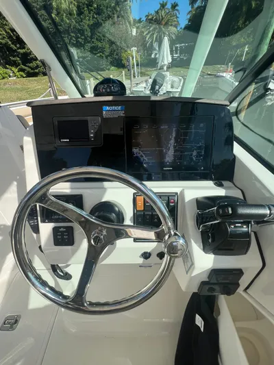  Yacht Photos Pics 2020 Pursuit 266 boat dashboard with steering wheel and control panel.