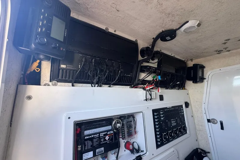 The Madd House Yacht Photos Pics 2023 Twin Vee 400 GFX CC boat interior with electronic control panels and wiring.