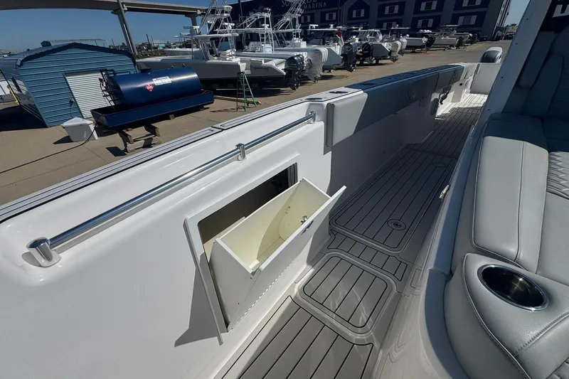 The Madd House Yacht Photos Pics 2023 Twin Vee 400 GFX CC boat interior with open storage compartment and seating area.