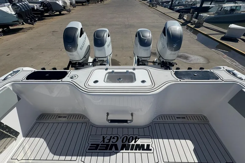 The Madd House Yacht Photos Pics 2023 Twin Vee 400 GFX CC boat with four Suzuki outboard engines at a marina.