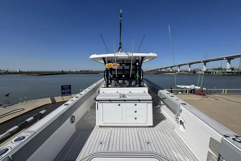 The Madd House Yacht Photos Pics 2023 Twin Vee 400 GFX CC boat docked by a waterfront with clear blue skies.