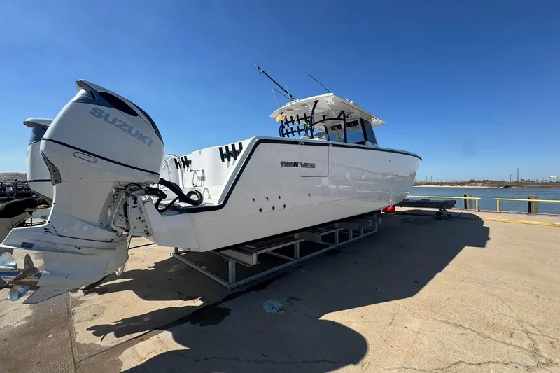 The Madd House Yacht Photos Pics 2023 Twin Vee 400 GFX CC boat with Suzuki engines on a dock.