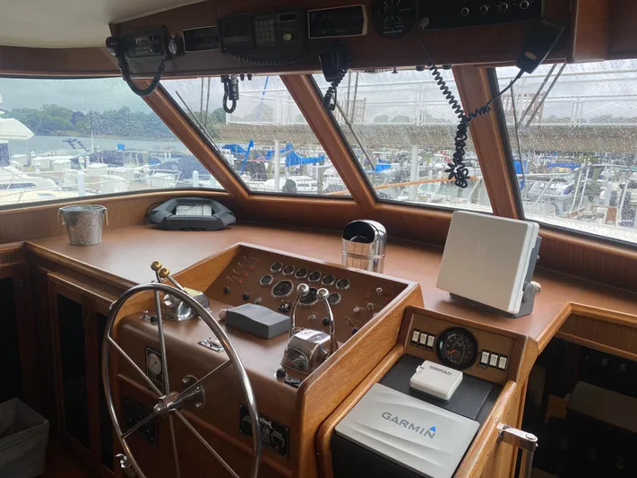  Yacht Photos Pics 1983 Hatteras 53 Motor Yacht helm with steering wheel, navigation equipment, and marina view.