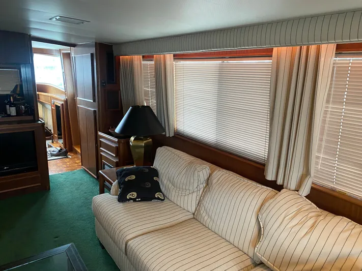 Yacht Photos Pics Interior of 1983 Hatteras 53 Motor Yacht with striped sofa and wooden cabinetry.