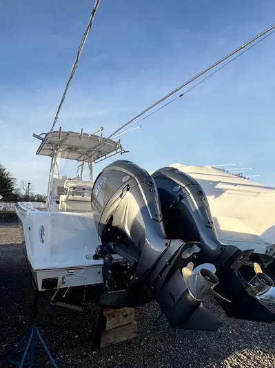  Yacht Photos Pics 2024 Contender 25 Tournament CC boat with dual outboard engines, parked on gravel.