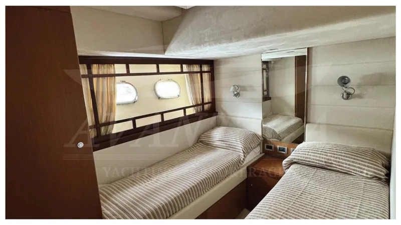  Yacht Photos Pics Twin cabin interior of 2008 Ferretti Yachts 731 with striped bedding and porthole windows.