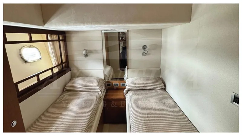  Yacht Photos Pics Twin cabin interior of 2008 Ferretti Yachts 731 with striped bedding and wall lights.