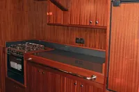 Wood-paneled kitchen in 2007 Motorsailer ВС-1800С with stove and fridge.