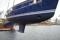 Blue Motorsailer ВС-1800С yacht from 2007, suspended above water at a shipyard.