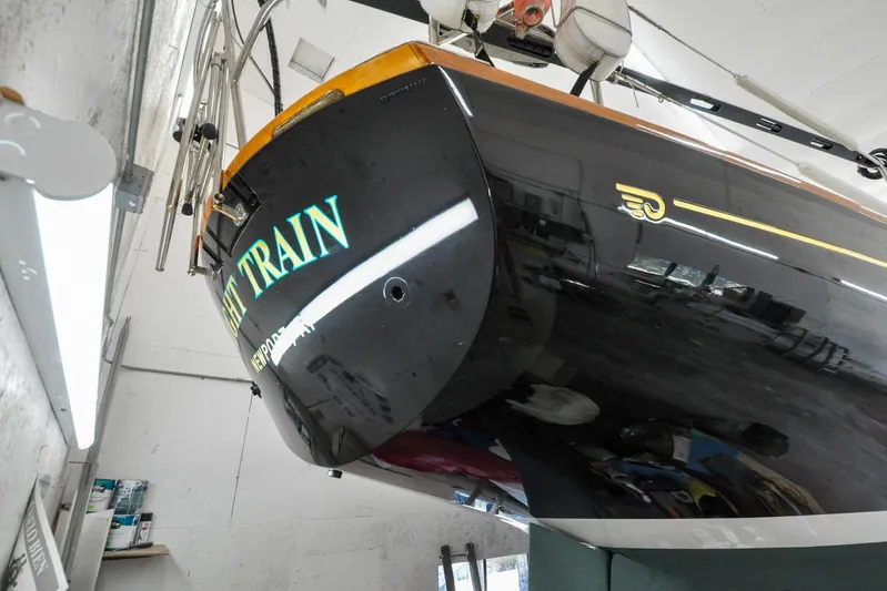 Night Train Yacht Photos Pics Hinckley Sou'wester 51 sailboat, 1986 model, in a workshop, showcasing sleek black hull design.