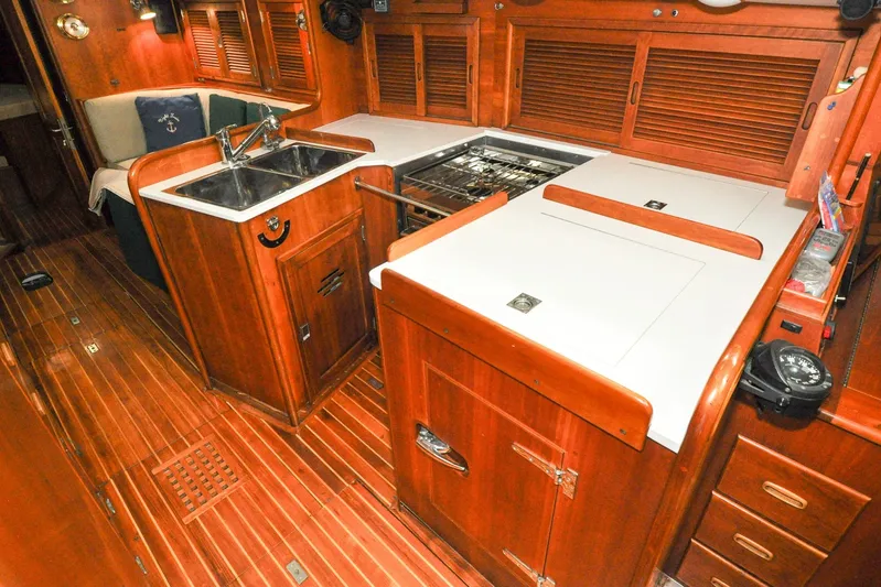 Night Train Yacht Photos Pics Interior of 1986 Hinckley Sou'wester 51 yacht, featuring a wooden galley with sink and stove.