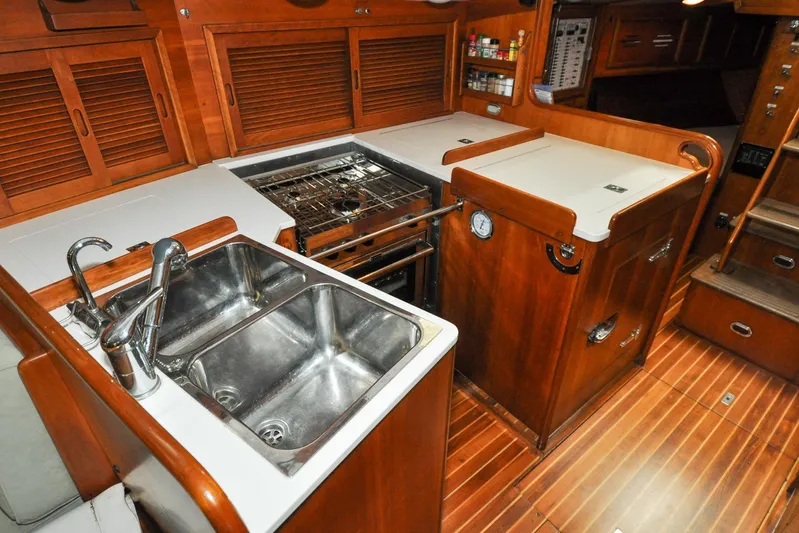Night Train Yacht Photos Pics 1986 Hinckley Sou'wester 51 yacht kitchen with dual sinks, stove, and wooden cabinetry.
