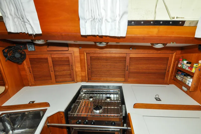 Night Train Yacht Photos Pics 1986 Hinckley Sou'wester 51 yacht kitchen with stove, wooden cabinets, and spice rack.
