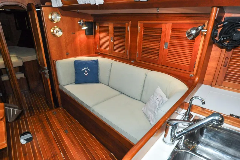 Night Train Yacht Photos Pics Interior of 1986 Hinckley Sou'wester 51 yacht with wooden finish and cozy seating area.