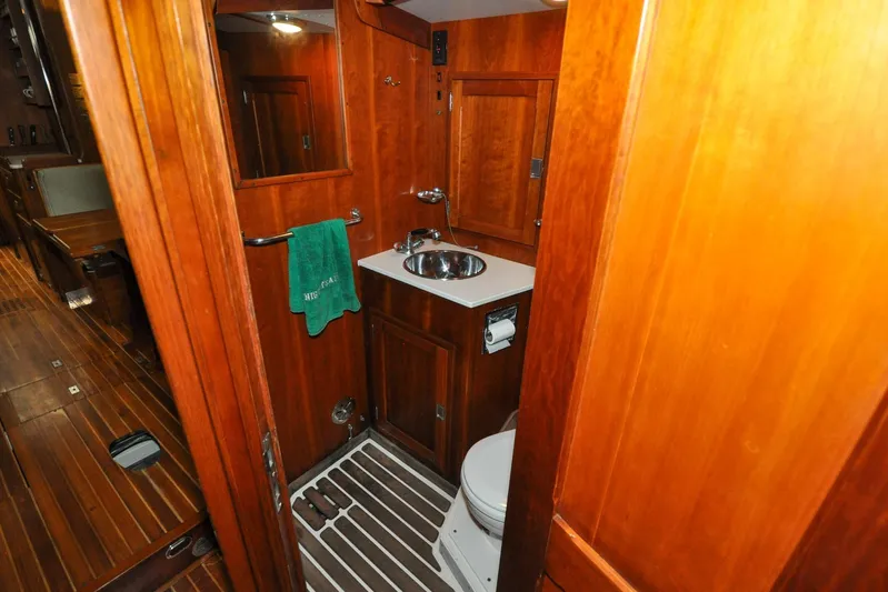Night Train Yacht Photos Pics 1986 Hinckley Sou'wester 51 yacht bathroom with wooden interior and compact amenities.