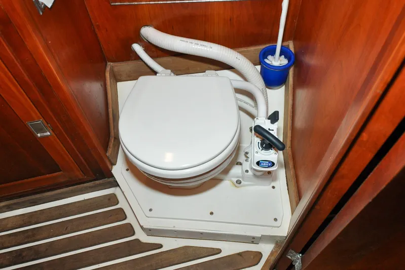 Night Train Yacht Photos Pics Hinckley Sou'wester 51 yacht bathroom with marine toilet, wooden paneling, and floor, 1986 model.