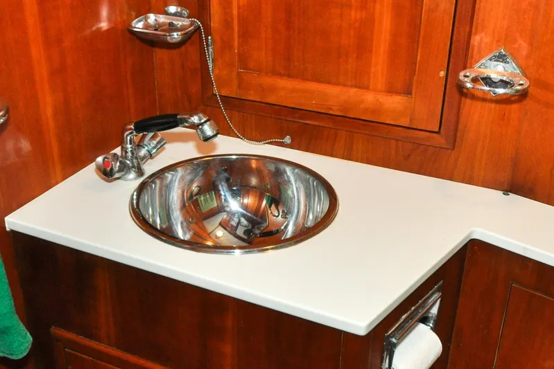 Night Train Yacht Photos Pics Stainless steel sink in 1986 Hinckley Sou'wester 51 yacht bathroom with wooden cabinetry.