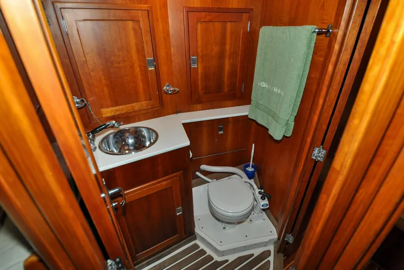 Night Train Yacht Photos Pics Hinckley Sou'wester 51 yacht bathroom, 1986 model, featuring wooden cabinetry and compact design.