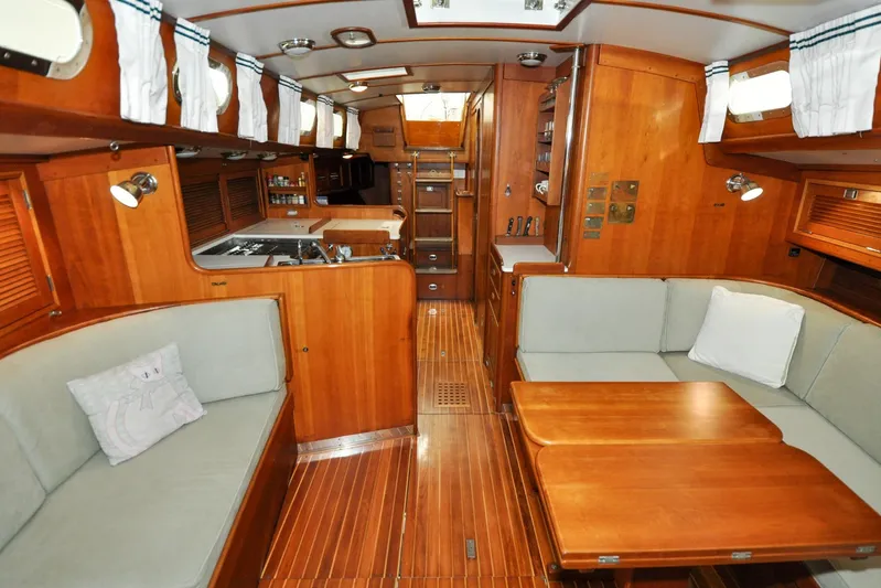 Night Train Yacht Photos Pics Interior of 1986 Hinckley Sou'wester 51 yacht with wooden finishes and cozy seating area.