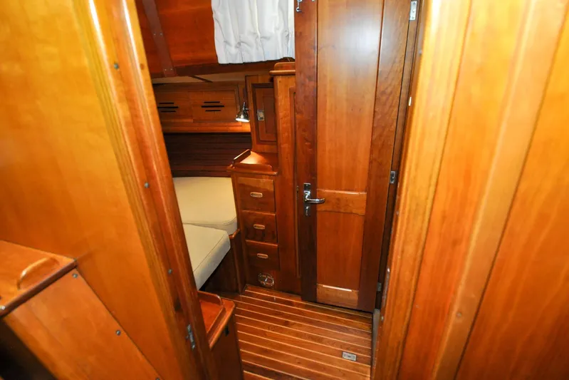 Night Train Yacht Photos Pics Interior of 1986 Hinckley Sou'wester 51 sailboat with wooden cabinetry and cozy sleeping area.