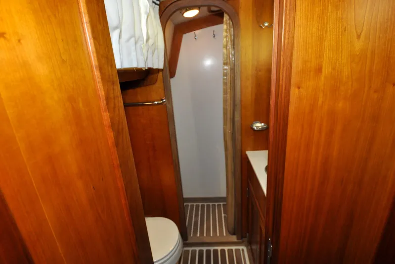 Night Train Yacht Photos Pics Interior of 1986 Hinckley Sou'wester 51 yacht bathroom with wooden cabinetry.